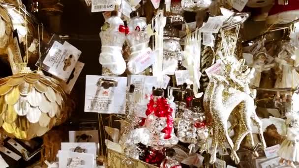 Niedliche Weihnachtsspielzeuge und Geschenke. Weihnachtsmarkt. Schaufenster mit weißen Keramikengeln, glänzenden Hirschen, Glaskugeln. Silvesterstimmung. Schöne Wohndekoration. 1. Dezember 2021 - Minsk, Weißrussland — Stockvideo