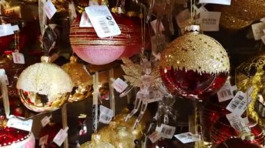 Kırmızı ve altın renkli cam topları olan bir dükkan vitrini, şeffaf bir melek. Güzel bir Noel oyuncağı ve hediye pazarı. Yılbaşı arifesi ruhu. Güzel bir ev dekorasyonu. 1 Aralık 2021 - Minsk, Belarus