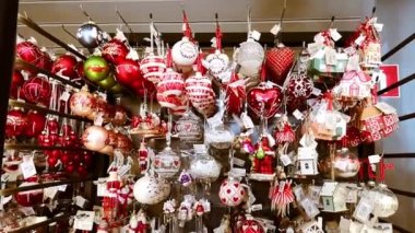 Kırmızı beyaz Noel oyuncağı topları, bebekler, fındık kırıcılar, ahşap evler olan bir mağaza vitrini. Yakın plan. Güzel oyuncak pazarı ve hediyeler. Klasik dekor. Ev dekorasyonu. 1 Aralık 2021 - Minsk, Belarus