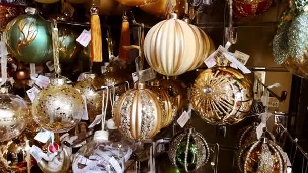 Shop vitrine met gouden glanzende glazen ballen. Leuk kerstspeelgoed en cadeautjes. Kerstmarkt. Oudejaarsavond. Prachtige huisdecoratie. 1 december 2021 - Minsk, Wit-Rusland — Stockvideo