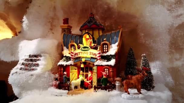 Instalação de brinquedos de Natal de miniaturas festivas com casa de jardim zoológico e Papai Noel, árvore de Ano Novo, animais e meninos de pessoas pequenas. Veado, ovelha. Mostra de mercado. 1 de dezembro de 2021 - Minsk, Bielorrússia — Vídeo de Stock