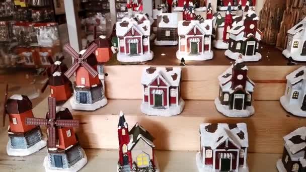 Vitrine de magasin avec maisons en céramique faites à la main. Gros plan. Marché aux jouets mignon et cadeaux de Noël. Décor de maison vintage. Décorations de vacances du Nouvel An. Petites bougies confortables — Video