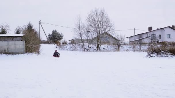 チューブ ライディング チューブ 男は雪の丘を転がっている 屋外の冬の楽しみ 家族のレジャー アクティブウォーク 季節の娯楽 自然を背景に 大きな雪原だ — ストック動画