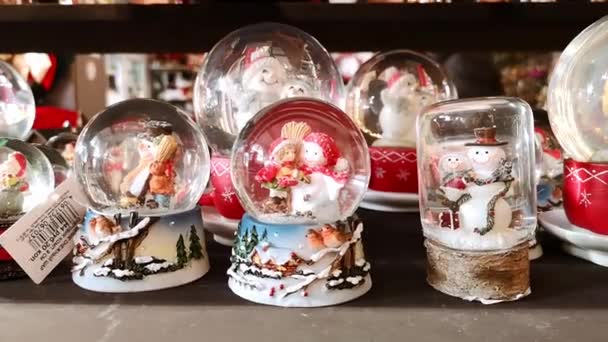 Магазин з великими і малими сніговими кульками. подарунок на Різдво і Новий рік. Сноумани, Санта Клаус і оглядачі. Зблизька. Крихітний ринок іграшок і подарунків. Вінтаж, домашній декор. 1 грудня 2021 - Мінськ (Білорусь). — стокове відео