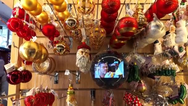 Mostra da loja com bolas de brinquedo de árvore de Natal de ouro vermelho branco e grande tela inteligente na esfera. Bonito mercado de brinquedos e presentes. Férias. Vintage loja de decoração de casa. 1 de dezembro de 2021 - Minsk, Bielorrússia — Vídeo de Stock