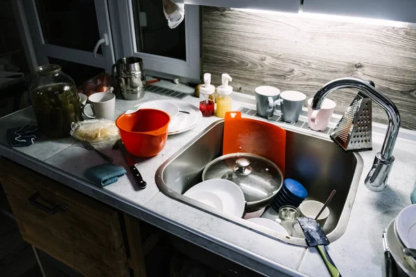 4K. A pile of dirty dishes on the table and in the kitchen sink. Plates in leftover food. Routine homework. Cleaning concept after guests. A very unkempt house. Nobody. Sloppy look. Video footage — Stock Photo, Image