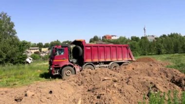 19 Haziran 2021 - Minsk, Belarus. Büyük bir çöp kamyonu toprağı inşaat alanına getirdi ve boşalttı. Yüklü bir kamyon. Yaz inşaat sezonu. Toprak taşıma. Büyük bir araç. Genel görünüm