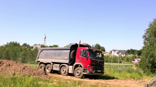 19 de junho de 2021 - Minsk, Bielorrússia. Um grande caminhão basculante dirige para trás através de um canteiro de obras. Camião com carga. Temporada de verão. Transporte terrestre. Veículo grande. Vista comum. Imagens de vídeo — Vídeo de Stock