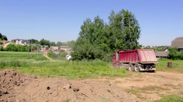 2021年6月19日-ベラルーシのミンスク。大規模なダンプトラックは、建設現場を後方に駆動します。荷を背負って。夏の建物の季節。地球の輸送だ。大きな車だ。一般的な見解。ビデオ映像 — ストック動画