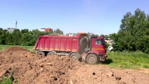 2021年6月19日-ベラルーシのミンスク。大規模なダンプトラックは建設現場を通って駆動します。荷を背負って。夏の建物の季節。地球の輸送だ。大きな車だ。一般的な見解。ビデオ映像だ。閉鎖 — ストック動画