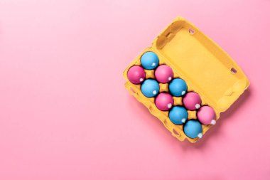 Beyaz tüylü kuyruklu tavuk yumurtaları paketi pembe arka planda değişik renklerde boyanmış Paskalya tavşanları gibi. Uzayı kopyala Pankart. Din tatili konsepti. Model tasarımı. Neon minimalist tarzı