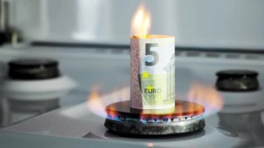 Gaz krizi kavramı. Mutfak ocağında beş avroluk banknot yanıyor. Avrupa nakit parası. Doğal kaynakların yüksek fiyatları. Ateş alevi. Kamu borcu. Enerji savaşı. Ev bütçesini biriktiriyorum. Finans