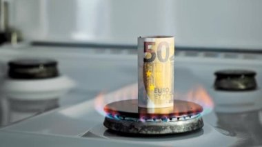 Gaz krizi kavramı. Mutfak ocağında 50 Euro 'luk banknot yanıyor. Avrupa nakit parası. Doğal kaynakların yüksek fiyatları. Ateş alevi. Kamu borcu. Enerji savaşı. Ev bütçesini biriktiriyorum. Finans
