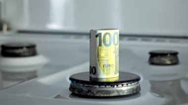 Gaz krizi kavramı. 100 Euro 'luk banknot bir mutfak ocağında yanıyor. Avrupa nakit parası. Doğal kaynakların yüksek fiyatları. Ateş alevi. Kamu borcu. Enerji savaşı. Ev bütçesini biriktiriyorum. Finans