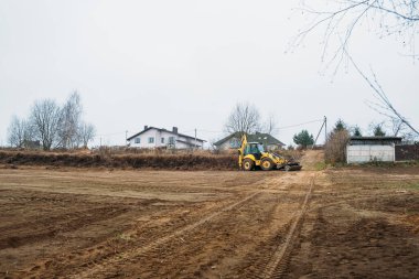Çekici seviye alanı. Yedek çapa yükleyicisi inşaat alanını temizliyor. Buldozer inşaat alanını hazırlıyor. Toprak taşıyıcı ekipman. Sınıf. Ön taraftaki yükleyici kovası. Belarus, Minsk 17 Kasım 2021