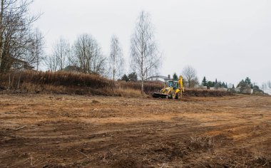 Çekici seviye alanı. Yedek çapa yükleyicisi inşaat alanını temizliyor. Buldozer inşaat alanını hazırlıyor. Toprak taşıyıcı ekipman. Sınıf. Ön taraftaki yükleyici kovası. Belarus, Minsk 17 Kasım 2021