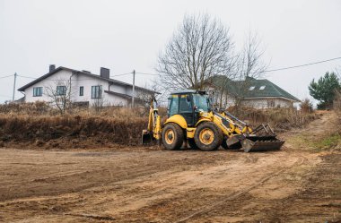 Çekici seviye alanı. Yedek çapa yükleyicisi inşaat alanını temizliyor. Buldozer inşaat alanını hazırlıyor. Toprak taşıyıcı ekipman. Sınıf. Ön taraftaki yükleyici kovası. Belarus, Minsk 17 Kasım 2021