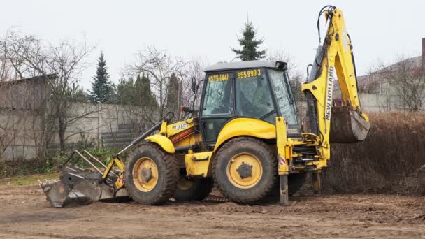 Hladinové pole traktoru. Backhoe nakladač čistí staveniště. Buldozer připravuje staveniště. Přepravní zařízení pozemšťanů. Grader. Kbelík předního nakladače. Bělorusko, Minsk 17. listopadu 2021 — Stock video