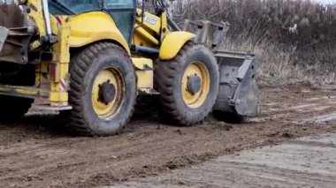 Çekici seviye alanı. Yedek çapa yükleyicisi inşaat alanını temizliyor. Buldozer inşaat alanını hazırlıyor. Toprak taşıyıcı ekipman. Sınıf. Ön taraftaki yükleyici kovası. Belarus, Minsk 17 Kasım 2021