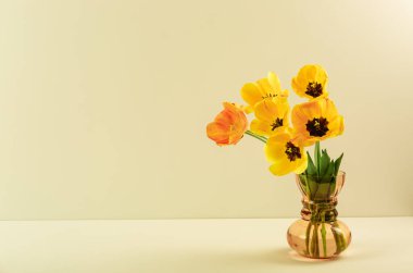 Büyük çiçek buketi sarı laleler bej renkli arka planda klasik cam vazoda. Uzayı kopyala Kartvizit. Davetiye kartı. Selamlama yeri. Uluslararası tatil. Pankart. Merhaba bahar..