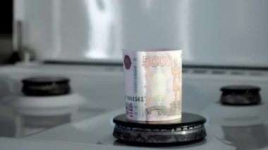 Gaz krizi kavramı. 5000 Rus rublesi mutfak ocağında yanıyor. Nakit para. Doğal kaynakların yüksek fiyatları. Ateş alevi. Kamu borcu. Enerji savaşı. Ev bütçesini biriktiriyorum. Finans