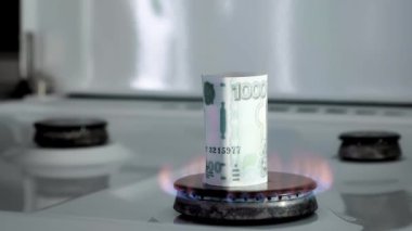 Gaz krizi kavramı. 1000 Rus rublesi mutfak ocağında yanıyor. Nakit para. Doğal kaynakların yüksek fiyatları. Ateş alevi. Kamu borcu. Enerji savaşı. Ev bütçesini biriktiriyorum. Finans