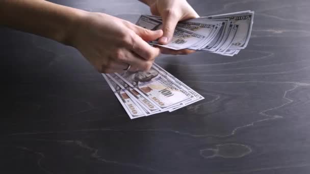 4K. La femme compte l'argent. Paquet de billets de 100 dollars américains. Processus de comptage. Crise économique mondiale. Corruption. Concept de l'argent sale. Met sur la table en bois. Vue latérale. Gros plan. Cent. Images vidéo — Video