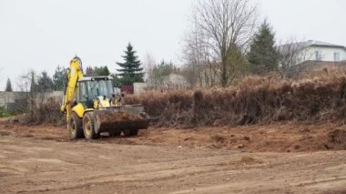 Çekici seviye alanı. Yedek çapa yükleyicisi inşaat alanını temizliyor. Buldozer inşaat alanını hazırlıyor. Toprak taşıyıcı ekipman. Sınıf. Ön taraftaki yükleyici kovası. Belarus, Minsk 17 Kasım 2021