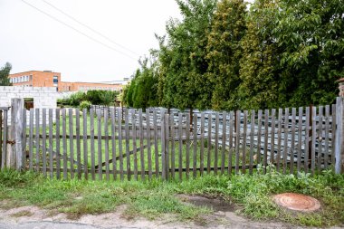 Eski tahta çitler. İnşaat tarafı. Yaz sezonu. Şeffaf ahşap çit. Tamamlanmamış bina.