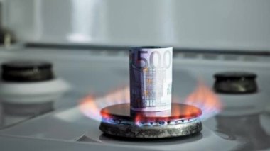 Gaz krizi kavramı. Mutfak ocağında 500 Euro 'luk banknot yanıyor. Avrupa nakit parası. Doğal kaynakların yüksek fiyatları. Ateş alevi. Kamu borcu. Enerji savaşı. Ev bütçesini biriktiriyorum. Finans