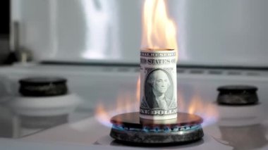 Gaz krizi kavramı. Mutfak ocağında 100 dolarlık banknot yanıyor. Nakit para. Doğal kaynakların yüksek fiyatları. Ateş alevi. Kamu borcu. Enerji savaşı. Ev bütçesini biriktiriyorum. Finans