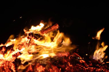 Ateşle. Siyah arka planda bir alev. Tasarımcılar için bir geçmiş. Cehennemin renkleri. Soyut ateş dokusu.