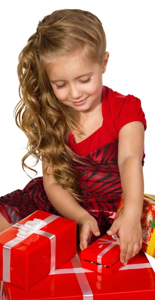 Beautiful little girl looking box set with presents — Stock Photo, Image