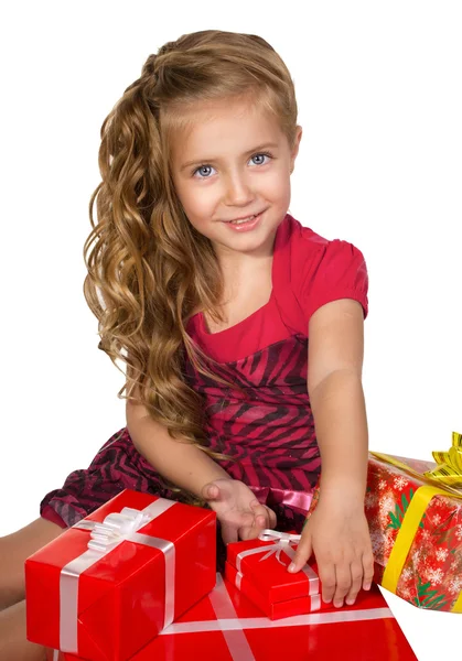 Schöne kleine Mädchen sitzt mit Geschenken in einem Box-Set — Stockfoto