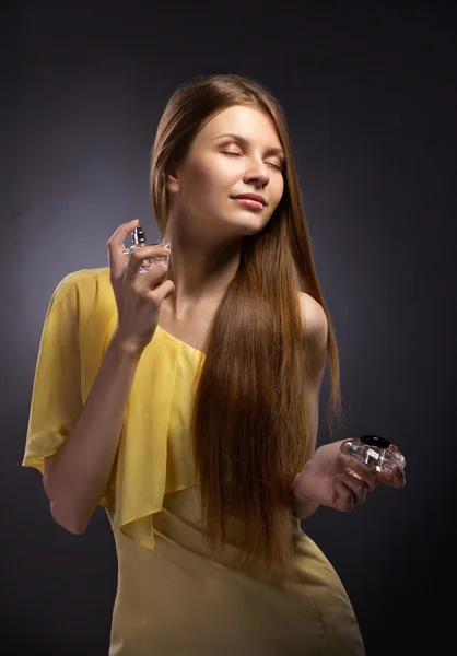 Beautiful young woman spraying perfume — Stock Photo, Image