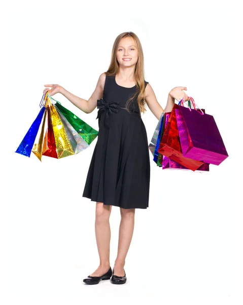 Krásná dívka v elegantní černé šaty s mnoha barev bag — Stock fotografie