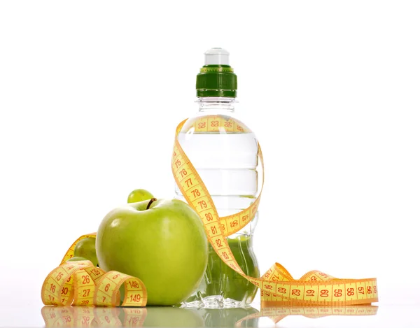 Green apple, bottle with aqua and small grapes — Stock Photo, Image