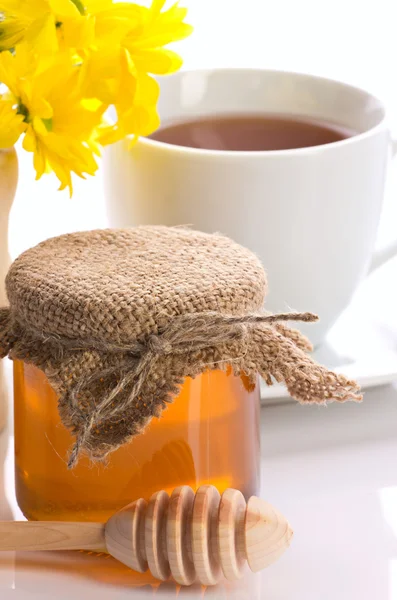 Крупный план меда, чая и цветов — стоковое фото