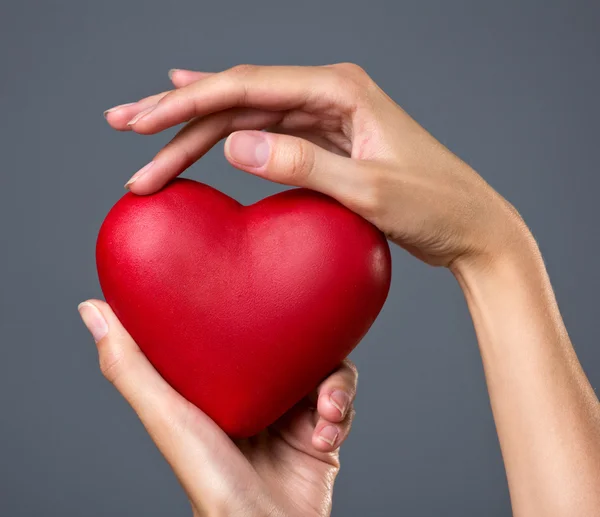 Corazón rojo en las manos — Foto de Stock