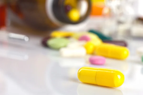 Yellow capsule and different medicaments — Stock Photo, Image