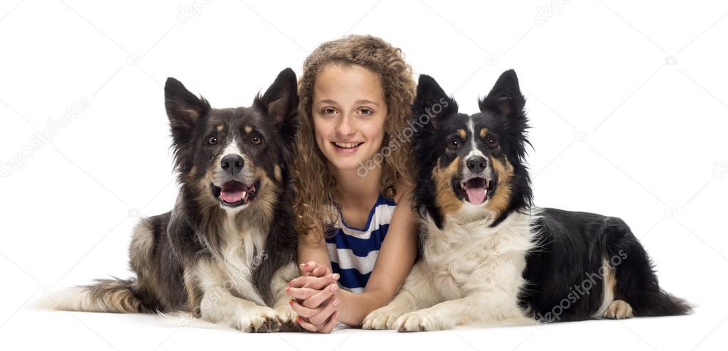 Young girl lying between two Border Collies against white background