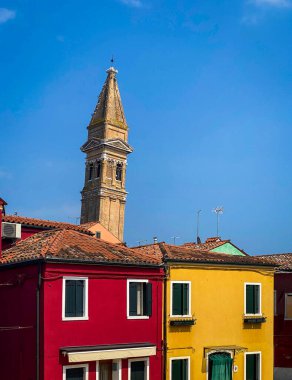 Burano 'da renkli boyanmış ön evler arka planda San Martino kilisesinin eğimli çan kulesi, seyahat arka planı, İtalya