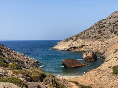 Yaz tatillerinde Amorgos adasındaki Batık Olympia teknesini, kıyı kayalıklarında, Kiklad 'da, Yunanistan' da ziyaret eden insanlar. Seyahat arkaplanı