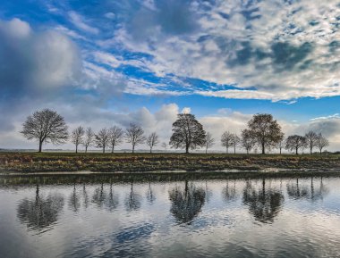 Su yansıması üzerine ağaçlar ve bulutlar, Saint-Valery _ sur _ Somme, Fransa 