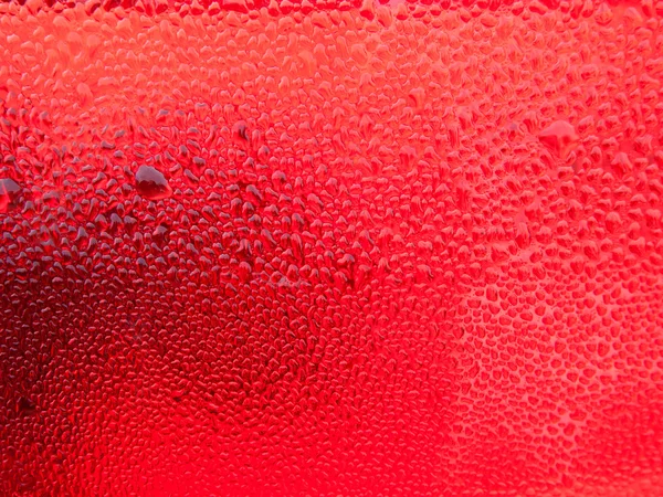 Капли росы на красном пластике — стоковое фото