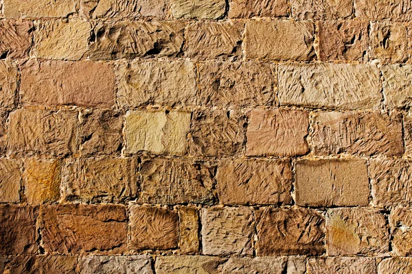 A superfície de uma parede de pedra à luz do sol — Fotografia de Stock