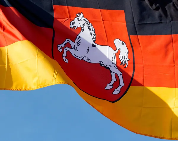 Duitse vlag van Neder-Saksen tegen blauwe hemel — Stockfoto