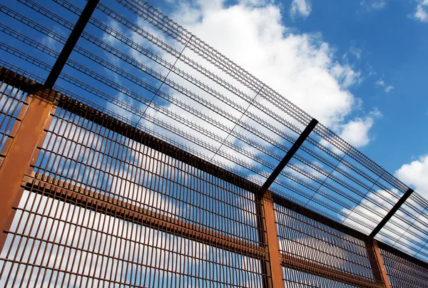 Security fence against blue sky — Stock Photo, Image