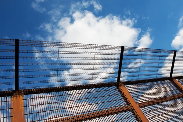 Sicherheitszaun gegen den blauen Himmel — Stockfoto