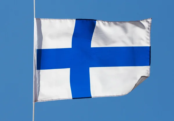 Die finnische Flagge im Wind gegen den Himmel — Stockfoto